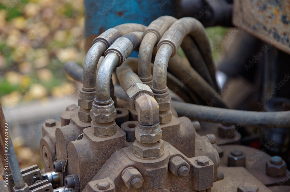 A close-up of pipe system of hydraulic valves in industrial machinery. A close-up of pipe system of hydraulic valves in industrial machinery.