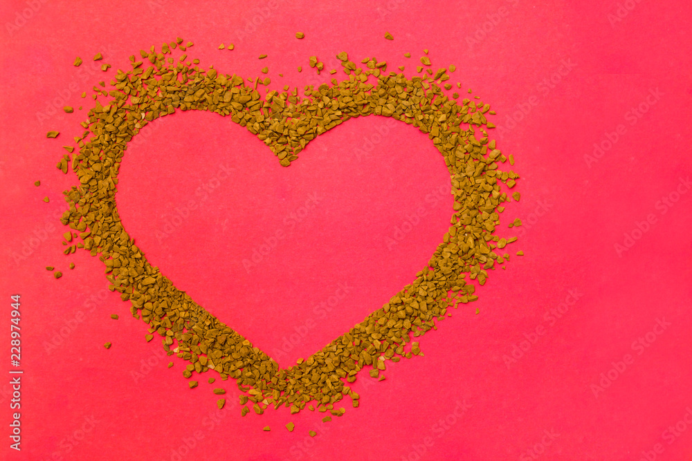 Dry instant coffee granules in the shape of a heart - brown texture