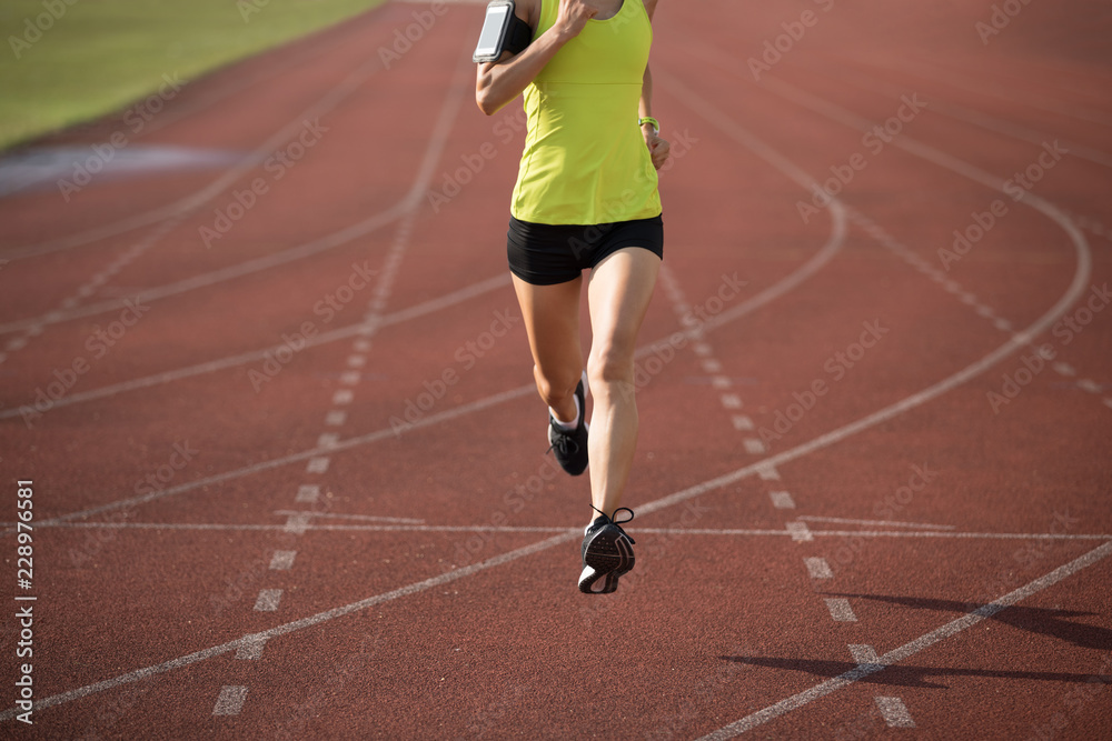 Fitness sportswoman running on stadium race tracks
