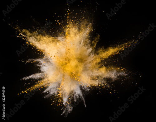 Explosion of yellow powder on black background