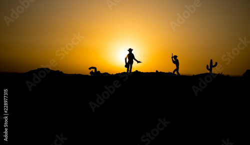Cowboy concept. Silhouette of Cowboys at sunset time. Cowboys silhouettes on a hill with horses.