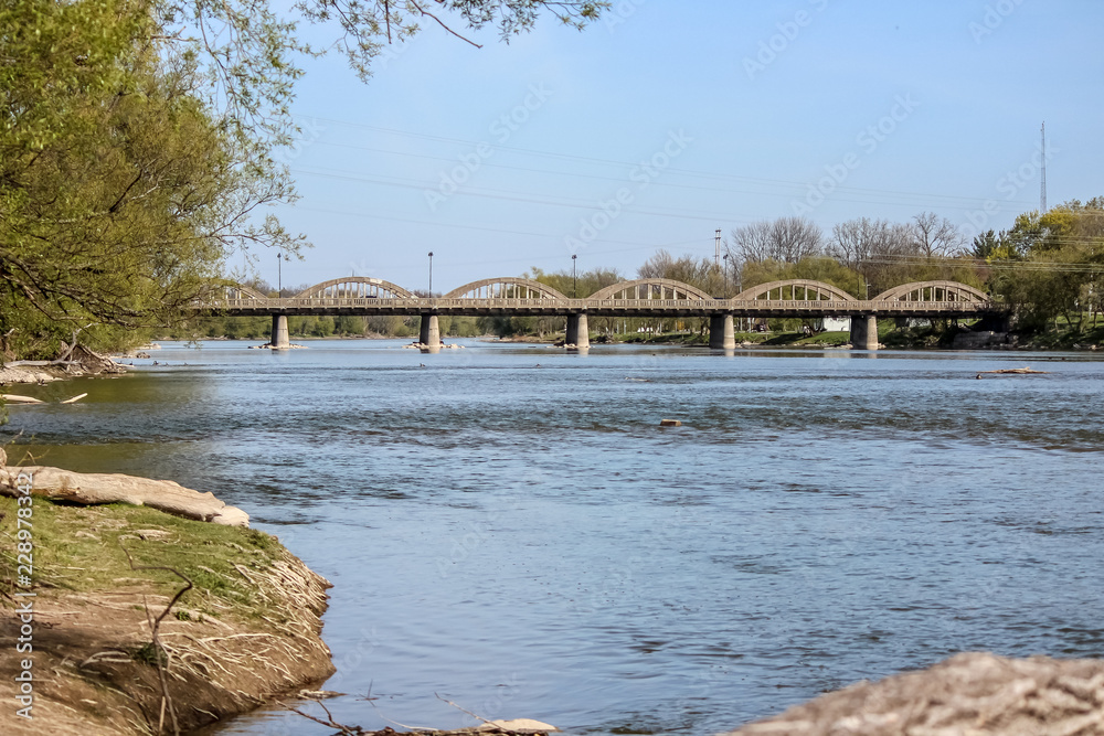 Looking Down the Grand River in Caledonia Ontario, Canada at a Concrete Car Bridge Crossing Shore to Shore.