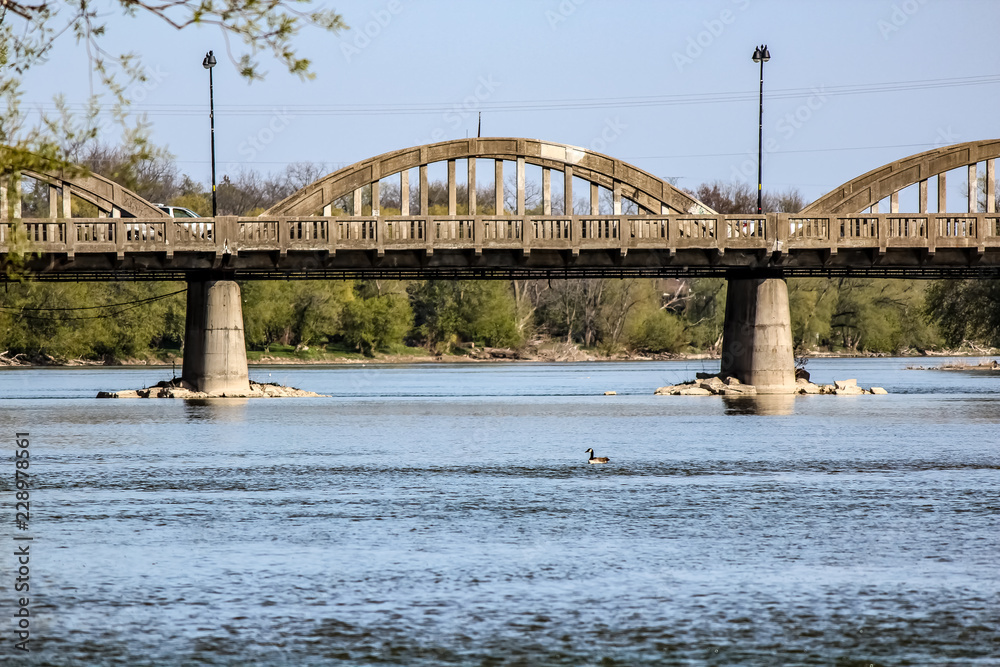 Looking Down the Grand River in Caledonia Ontario, Canada at a Concrete Car Bridge Crossing Shore to Shore.