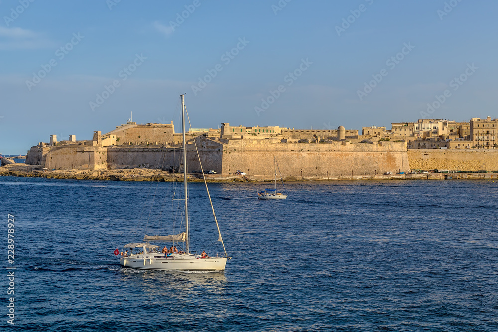 Valletta, Malta. Yacht in the background of the fort of Sant Elmo