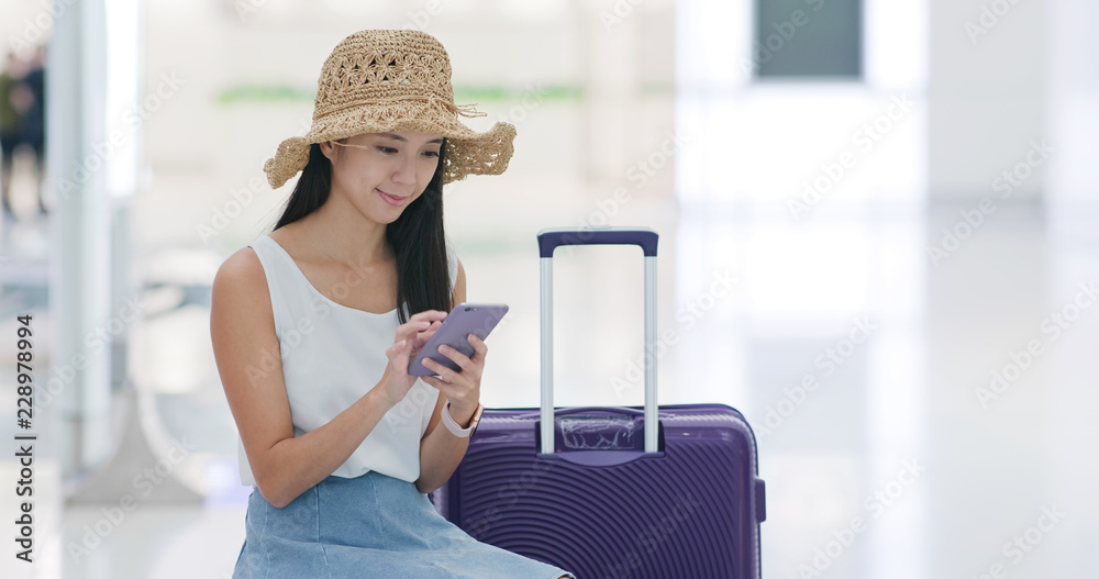 Woman go travel and wait in the airport with cellphone