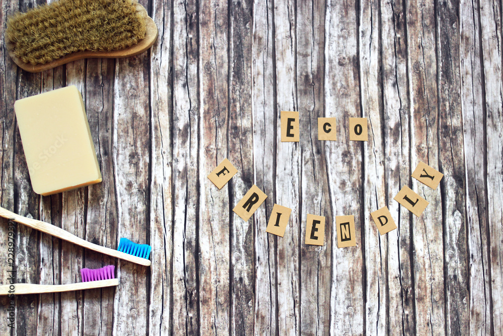 zero waste hygiene products on wooden background and text spelling 'eco friendly'