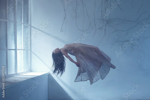 Foto Dreaming woman levitating in empty room
