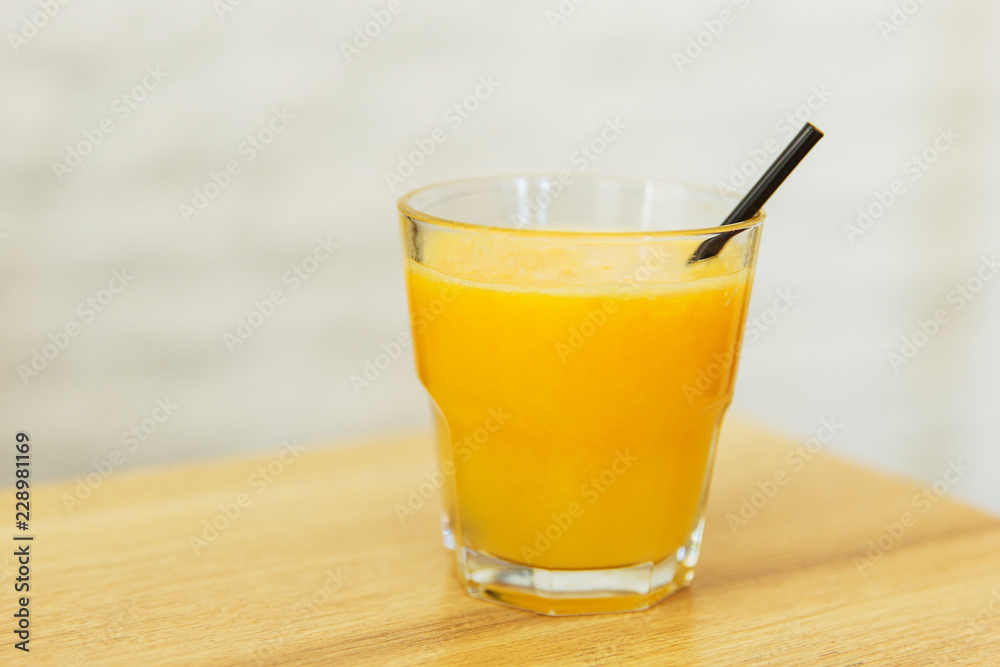 Orange juice in a glass on wooden table in a restaurant