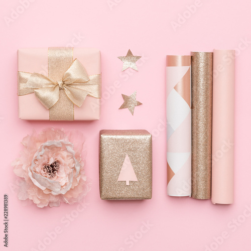 Gift wrapping. Pink and gold nordic christmas gifts isolated on pastel pink background. Wrapped xmas boxes.