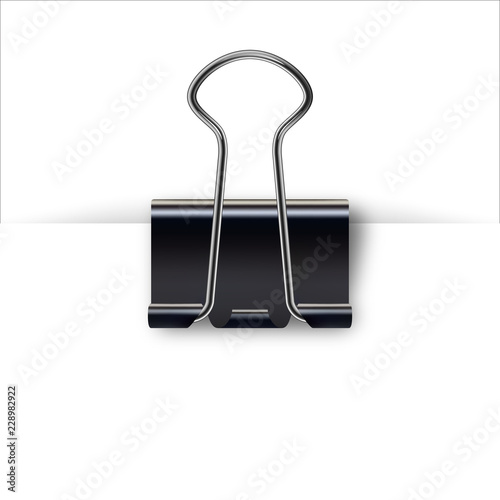 Binder clip for paper design. Realistic metallic black paper clip with shadow from a sheet of paper. photo