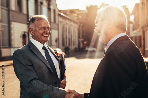 Senior business men greeting with a handshake