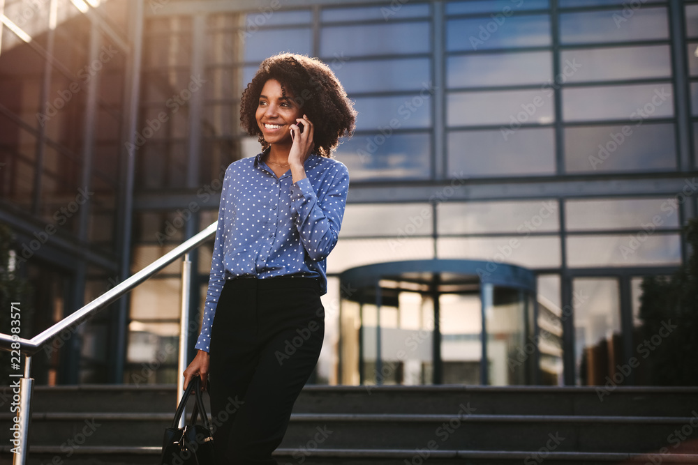 © Jacob Lund - Businesswoman walking outdoors talking on cell phone