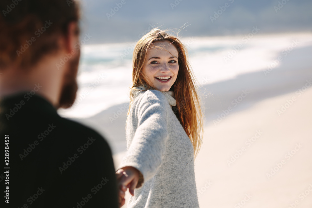 Beautiful woman walking with her boyfrined on beach
