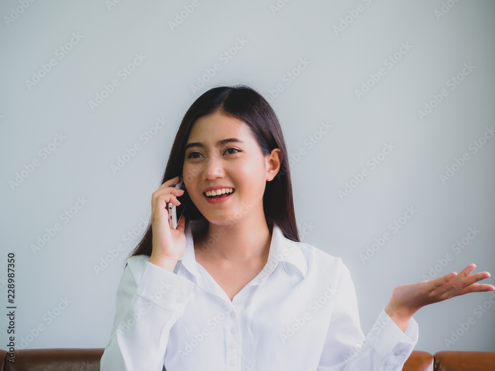 Pretty business woman sitting on sofa and using cell phone and reading something on laptop to communication technology with happiness Pretty business woman sitting on sofa and using cell phone and reading something on laptop to communication technology with happiness