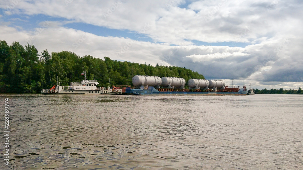 Transportation of goods on the river on a barge. Transportation of goods on the river on a barge.