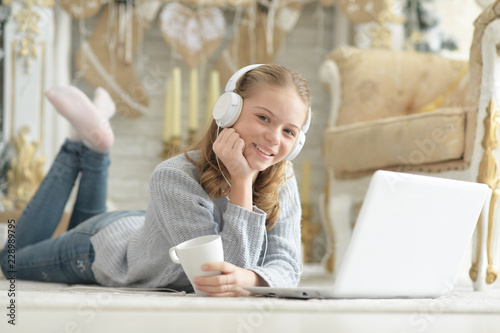 Portrait of teenage girl with headphones using laptop