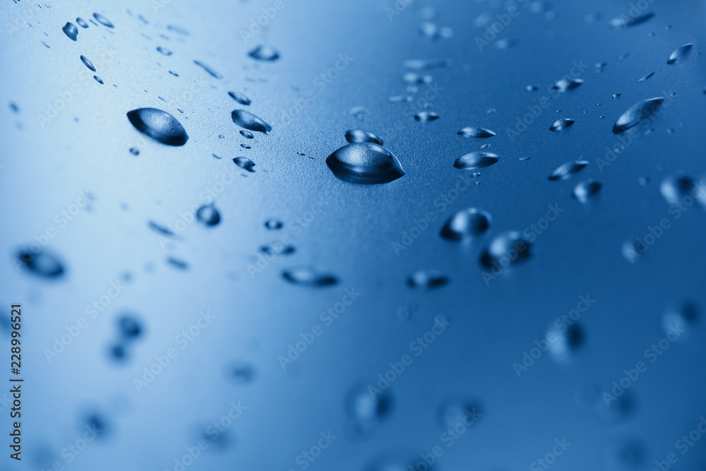 Drops of clean water on the glass. Blue background