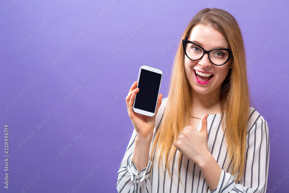 Young woman holding out a cellphone in her hand Young woman holding out a cellphone in her hand