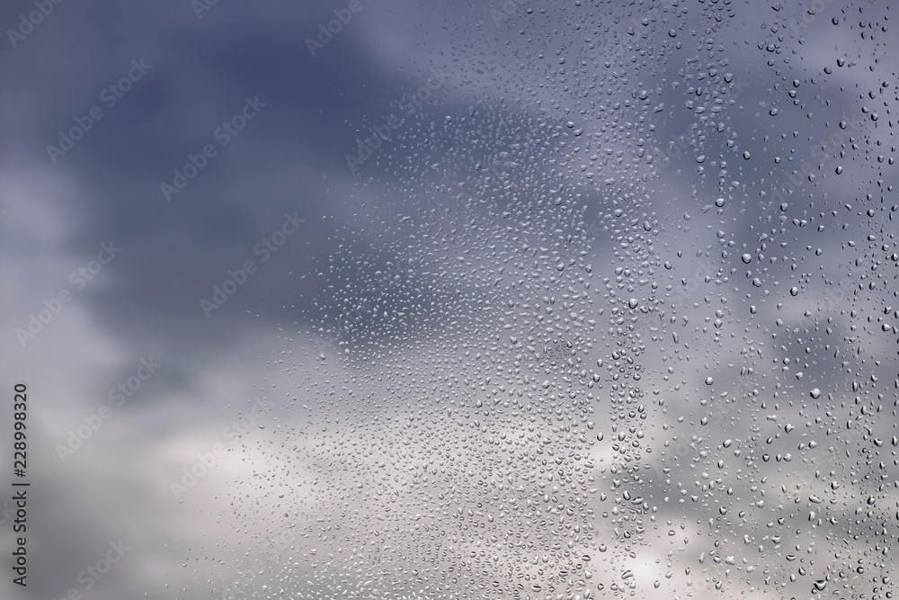 Rain / Water drop of rain on glass with blured blue sky background - sky afer rain. Rain / Water drop of rain on glass with blured blue sky background - sky afer rain.