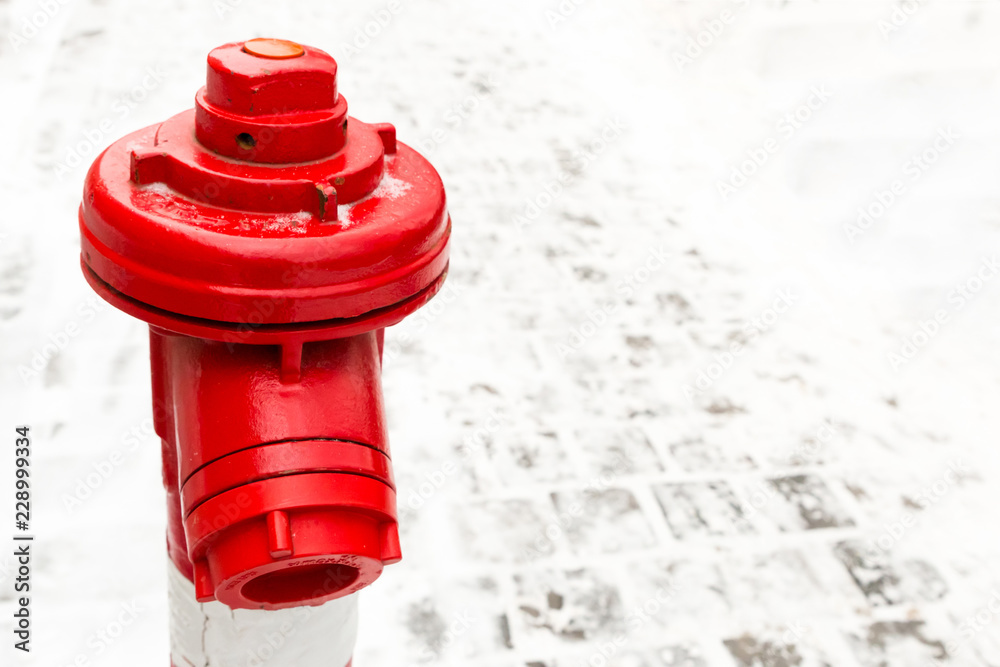 industrial background red hydrant close-up contrasting on a background of snow stone area copy space
