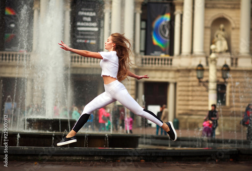 Girl ballerina gymnast posing on square of tourist town © okostia