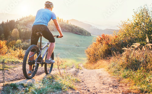 Mountain biker ride down from hill. Active and sport leisure concept