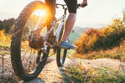 Mountain biker ride down from hill. Close up wheel image. Active and sport leisure concept