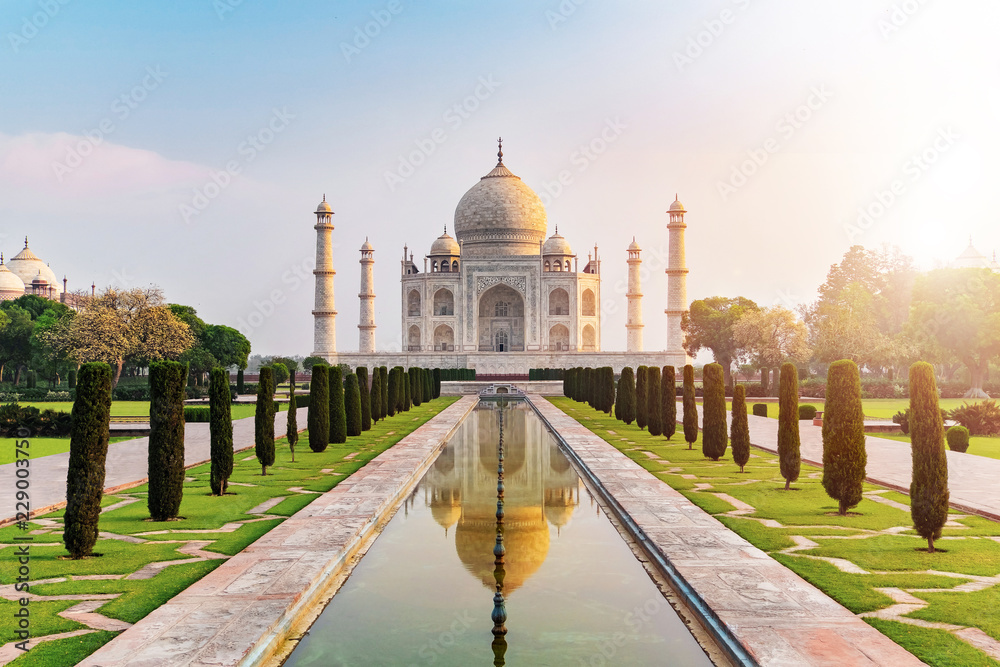 Fototapeta premium Sun rise at Taj Mahal front view reflected on the reflection pool, an ivory-white marble mausoleum on the south bank of the Yamuna river in Agra, Uttar Pradesh, India.