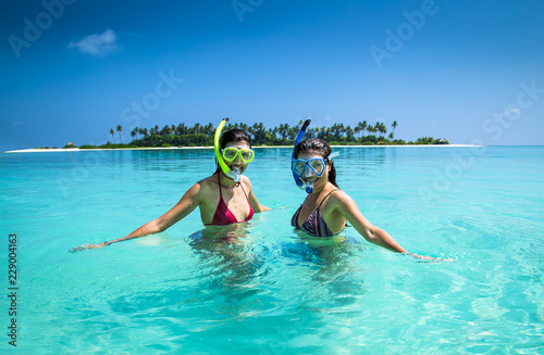 Two happy girls with diving mask at topical beach, Maldives.