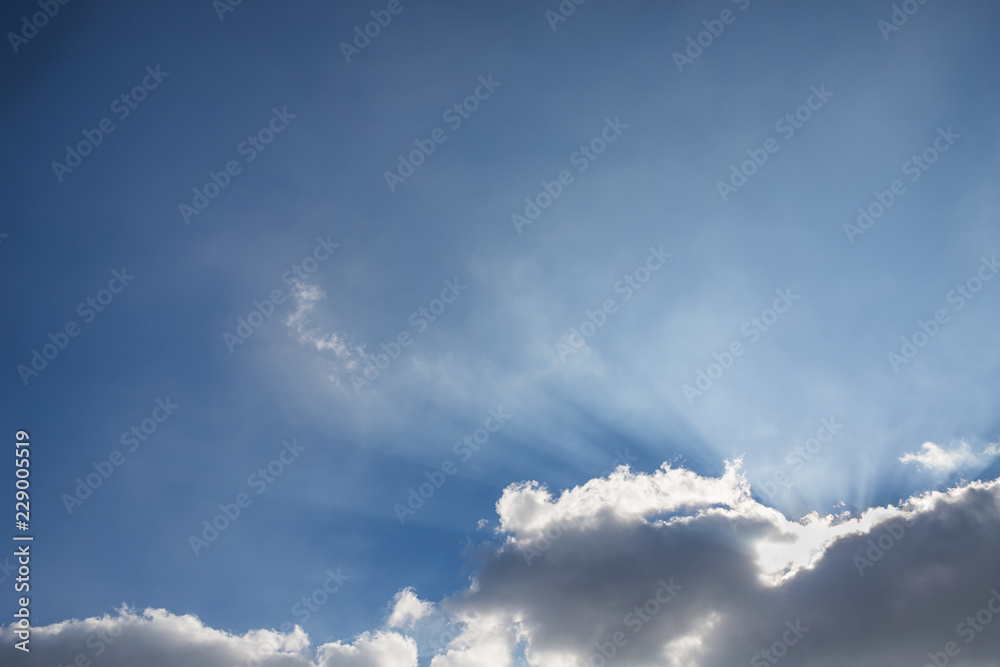 Obraz premium Beautiful blue sky with clouds and sun rays