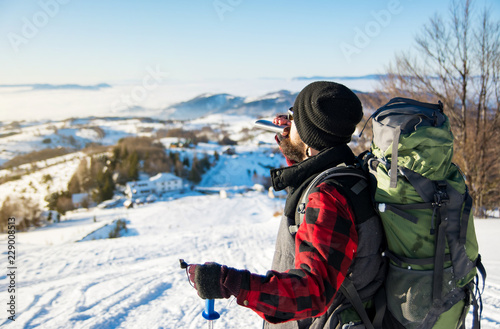Man drinking from a hip flask on snowy mountain