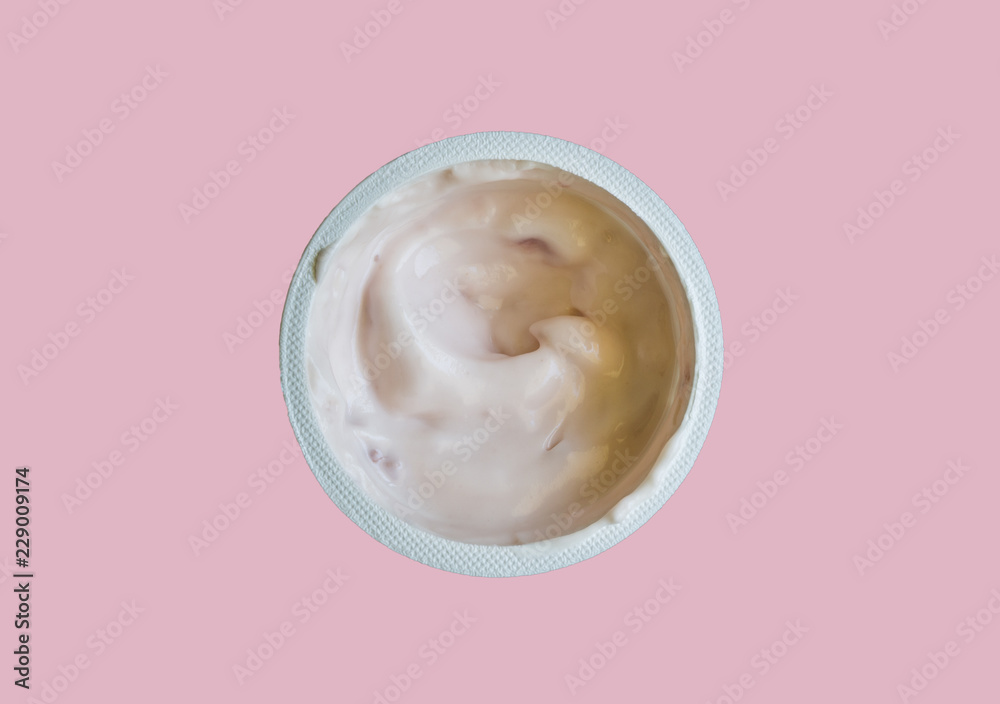 Yogurt in plastic cup close up top view photo of strawberry yoghurt on pink background Yogurt in plastic cup close up top view photo of strawberry yoghurt on pink background