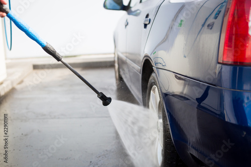 Shot of a man hands washing his car under high pressure water outdoors, cleaning concept