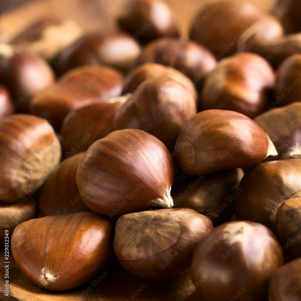 Obraz premium Fresh raw chestnuts, photographed with natural light (Selective Focus, Focus one third into the chestnuts)