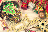 Beautiful Christmas composition and decoration with baked Christmas gingerbread cookie in paper bag on light wooden background, flat lay, top view, copy space (text space)