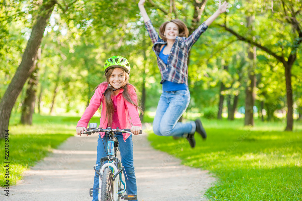 happy mother rejoices that her daughter learned to ride a bike happy mother rejoices that her daughter learned to ride a bike