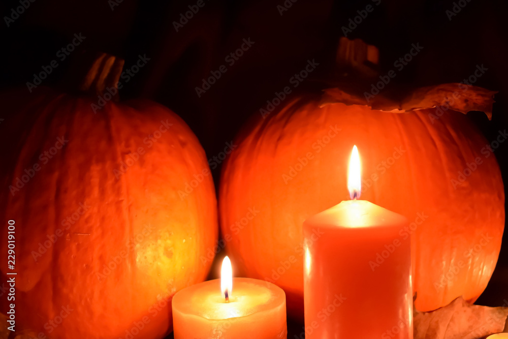 Halloween. Pumpkins, candles, autumn leaves on a black background. Scenery to celebrate Halloween. Halloween. Pumpkins, candles, autumn leaves on a black background. Scenery to celebrate Halloween.
