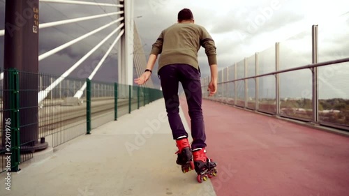 Young man in rollerblades riding in the city, super slow motion 
 photo