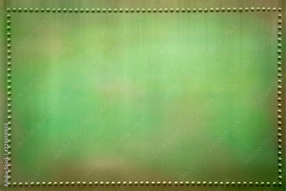 Obraz premium Green metal plate with small rivets.