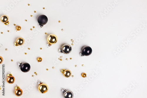 Christmas flat lay scene with golden, gray and black glass balls with copy space on white table