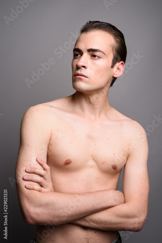 Young handsome man shirtless with arms crossed thinking