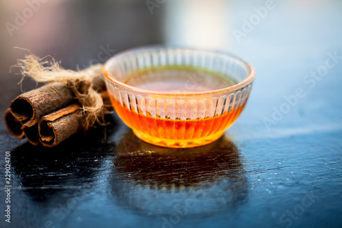 Ingredients of apple cider or apple cider vinegar i.e. raw apple or seb or malus, cinnamon stick and honey on wooden surface.Close up shot or top shot. photo
