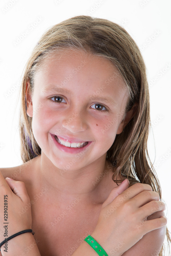 Smiling beauty child girl with crossed arms looking at the camera over white background Smiling beauty child girl with crossed arms looking at the camera over white background