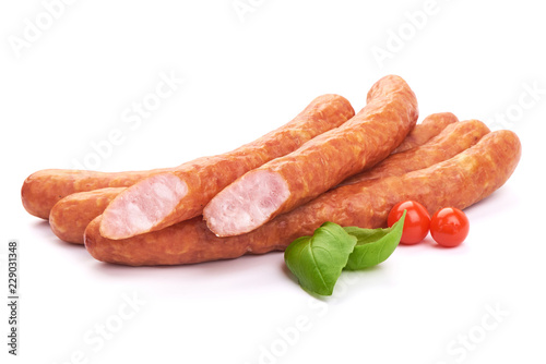 Sliced Hungarian dry sausages with basil leaves, isolated on a white background. Close-up photo