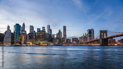 4k cinemagraph of New York City Manhattan, financial district skyline, cityscape at Brooklyn bridge park during sunset, dusk, night, twilight, skyscrapers, moving traffic, cars, light streaks