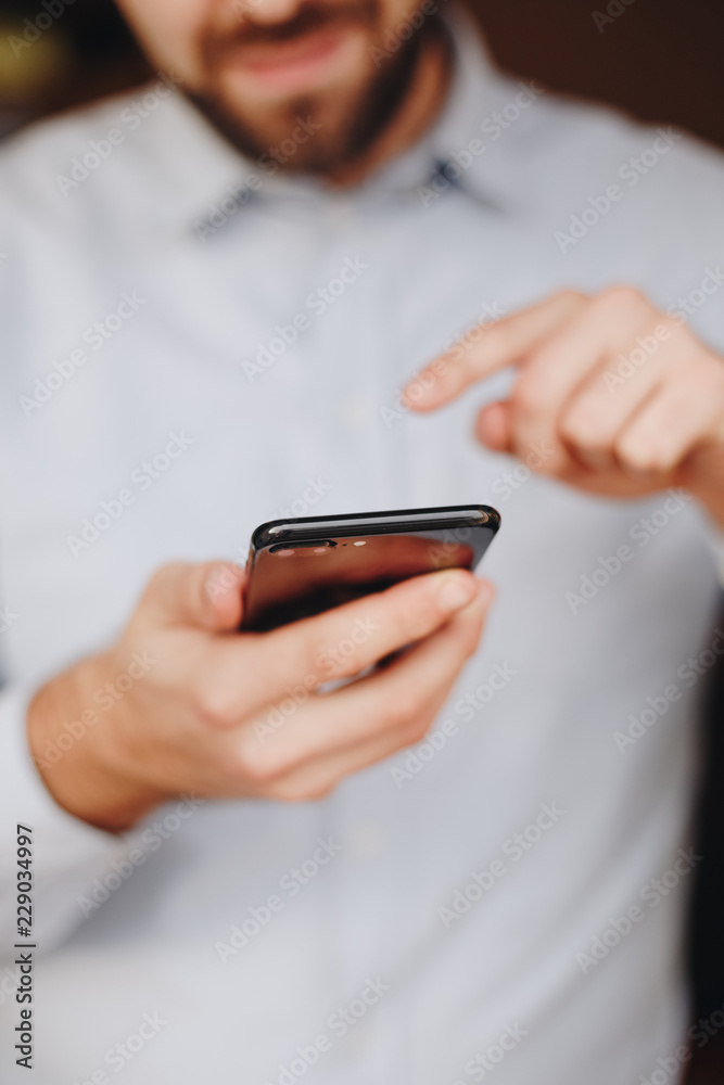 close up of man using smartphone. concept of phone addiction. young business man typing and browsing social media on his phone. close up of man using smartphone. concept of phone addiction. young business man typing and browsing social media on his phone.