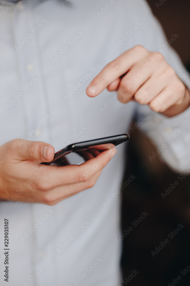 close up of man using smartphone. concept of phone addiction. young business man typing and browsing social media on his phone. close up of man using smartphone. concept of phone addiction. young business man typing and browsing social media on his phone.
