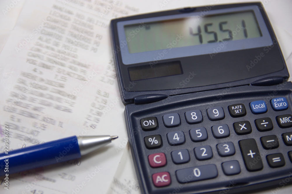 Calculator and pen to control daily expenses Calculator and pen to control daily expenses