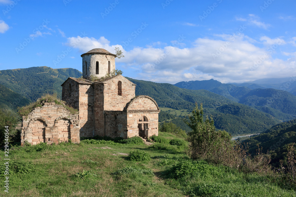 Old church in mountains, in national park Dombai, Caucasus, Russia. Summer landscape, sunshine weather, dramatic blue sky and sunny day