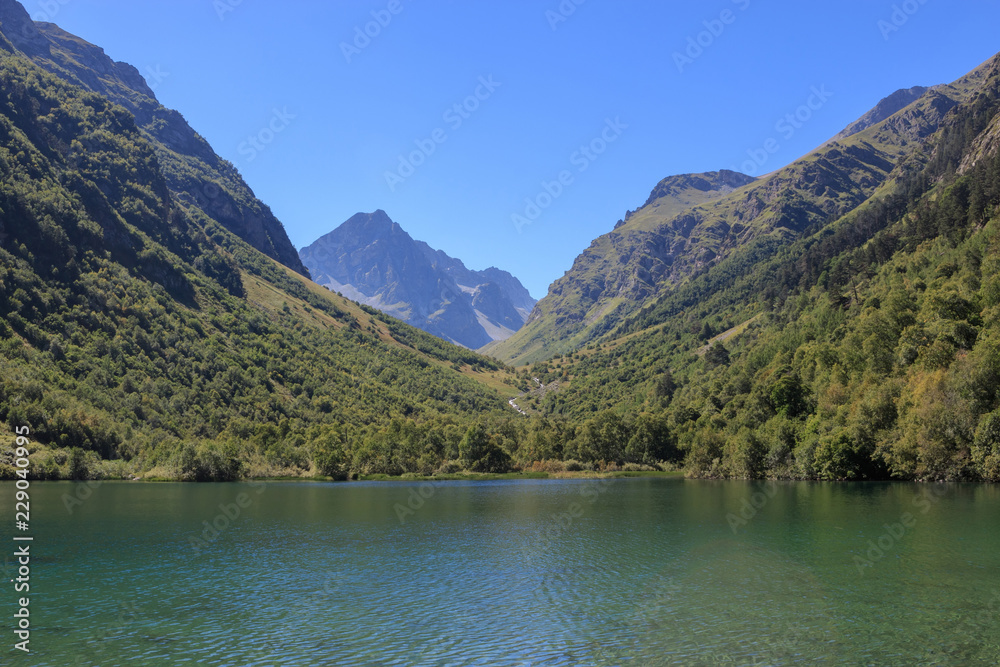 Lake scenes in mountains, national park Dombai, Caucasus, Russia, Europe. Sunshine weather, blue color sky, far away green trees. Colorful summer day, time Lake scenes in mountains, national park Dombai, Caucasus, Russia, Europe. Sunshine weather, blue color sky, far away green trees. Colorful summer day, time
